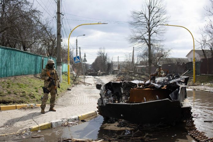 Żołnierze na środku ulicy pełnej rozbitych czołgów i zniszczonych budynków (Bucza). Zdjęcie ilustracyjne. / foto: PAP/Abaca