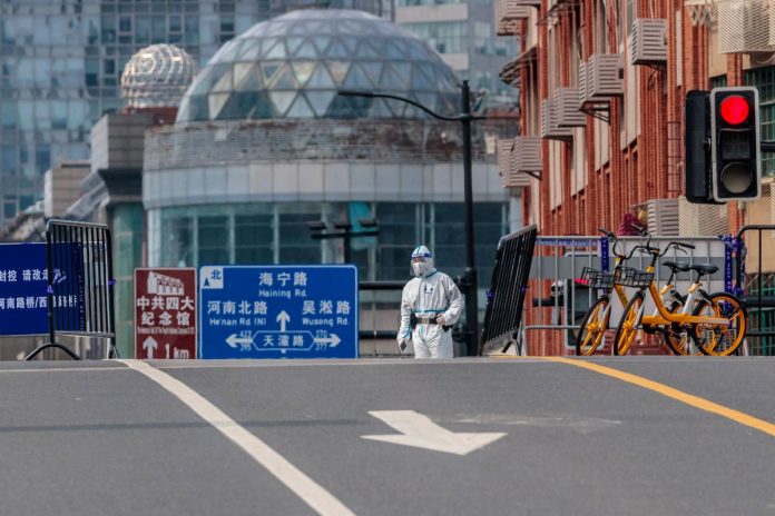 Szanghaj (Chiny). Policjant stoi na ulicznym punkcie kontrolnym. Zdjęcie ilustracyjne. / foto: PAP/EPA