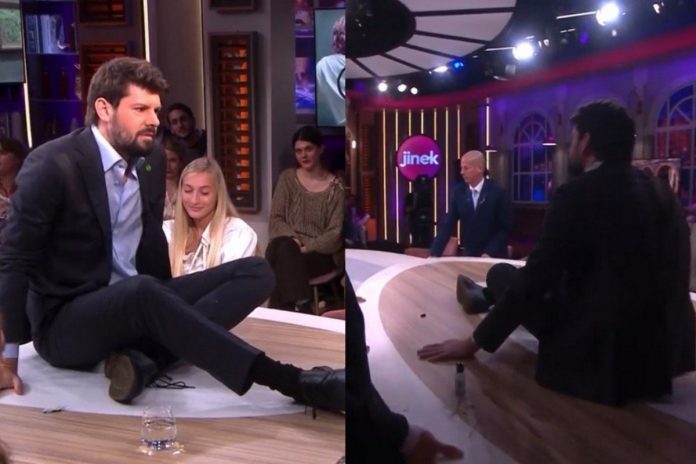 Jell-de-Graaf-przyklejanie-się-do-ścian-nczas Niderlandzki aktywista Jelle de Graaf przykleił się do stołu w programie na żywo Źródło: Twitter