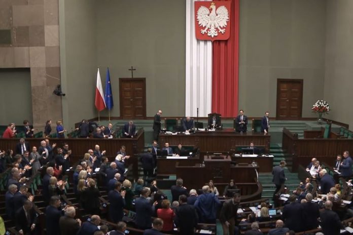 Posłowie w Sejmie po przyjęciu uchwały uznającej Rosję za państwo sponsorujące terroryzm wraz z poprawką PiS.