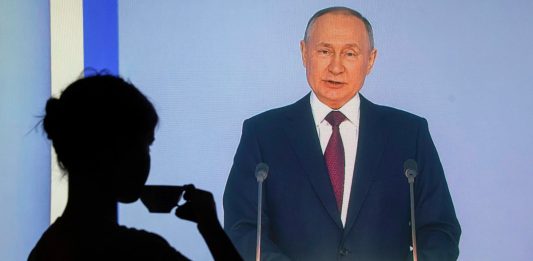 Kobieta oglądająca orędzie Władimira Putina w telewizji i pijąca herbatę Źródło: EPA/SERGEI ILNITSKY Dostawca: PAP/EPA.