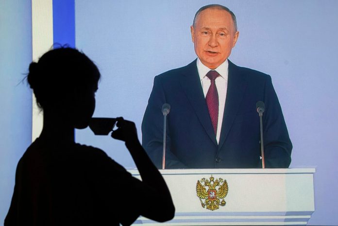 Kobieta oglądająca orędzie Władimira Putina w telewizji i pijąca herbatę Źródło: EPA/SERGEI ILNITSKY Dostawca: PAP/EPA.