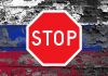 Znak "Stop" na tle rosyjskiej flagi.
