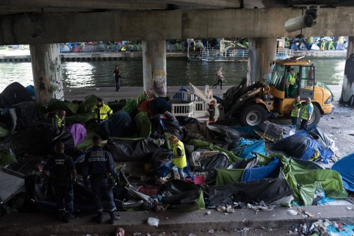 Sprzątanie prowizorycznego obozu migrantów wzdłuż Canal de Saint-Denis w północnym Paryżu.