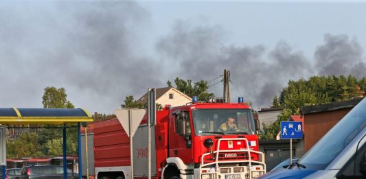 Wozy Straży Pożarnej biorą udział w akcji gaszenia pożaru hali, w której składowane były substancje niebezpieczne w zielonogórskim Przylepie, 22 lipca 2023 r. Zdjęcie: PAP/Lech Muszyński