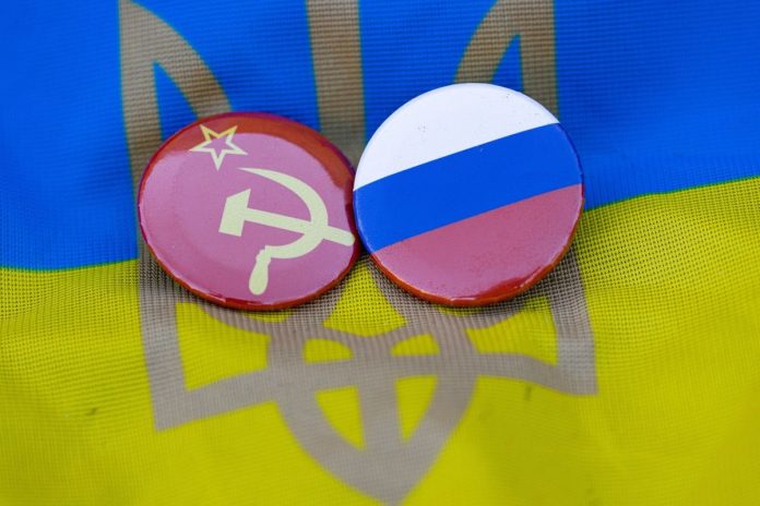 Flagi Rosji oraz ZSRR na tle flagi Ukrainy.