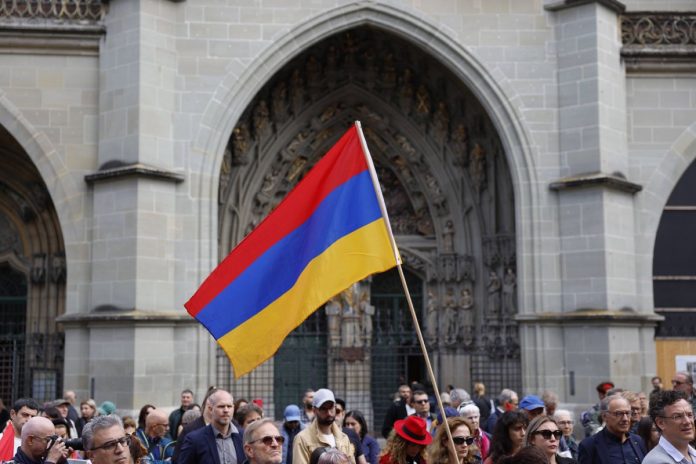 Flaga Armenii podczas protestu przeciw militarnej akcji Azerbejdżan w Górskim Karabachu.